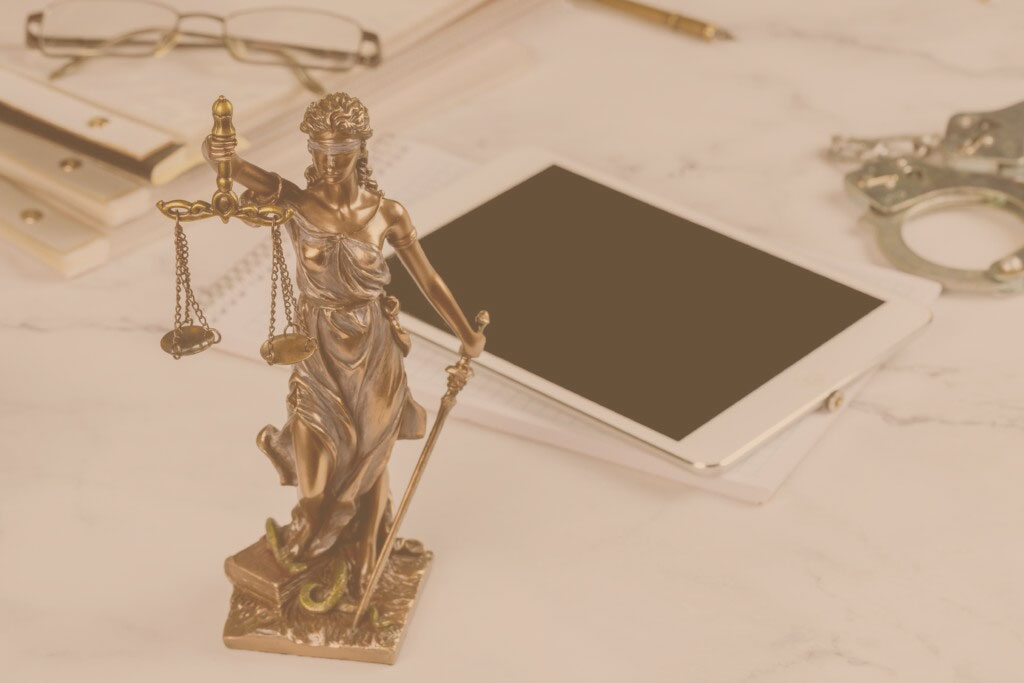 Lawyer office Statue of Justice with scales and lawyer working on a digital tablet